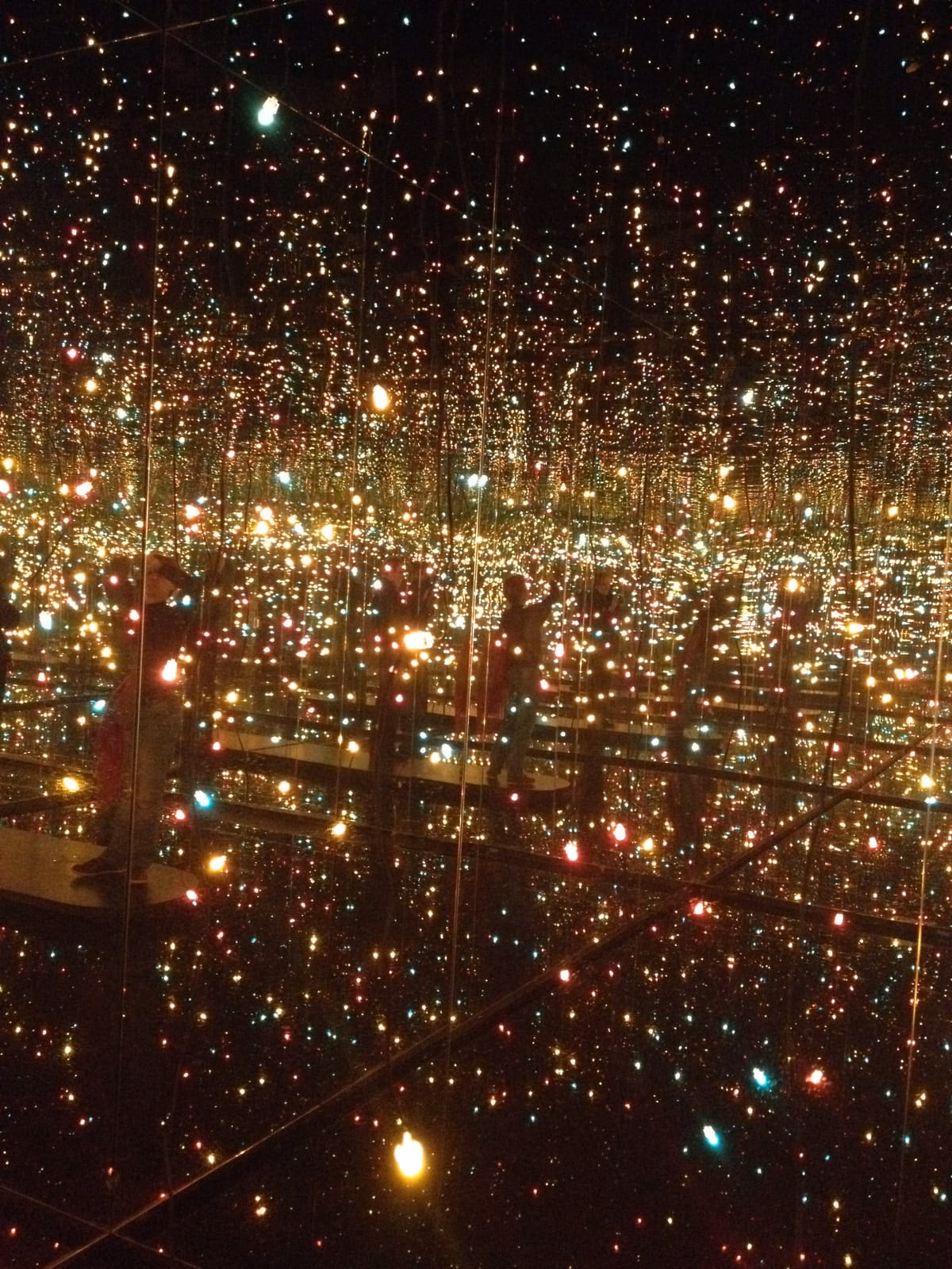 Une pièce entièrement tapissée de miroirs et de centaines de petites lumières colorées, qui se reflètent à l'infini.